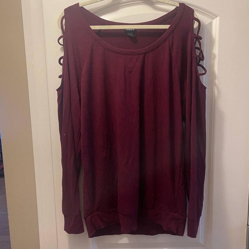 Red sweater with crossed openings on arm